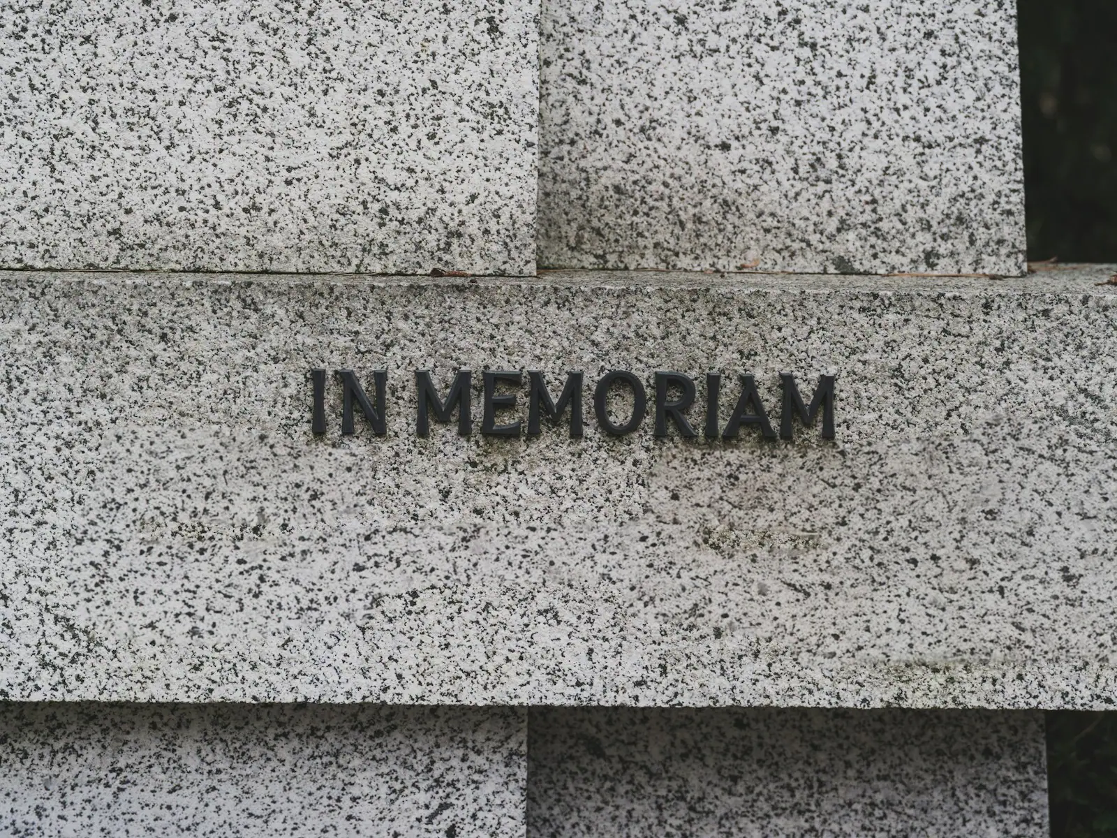 Sauberer Grabstein aus hellem Granit mit der Inschrift «In Memoriam»